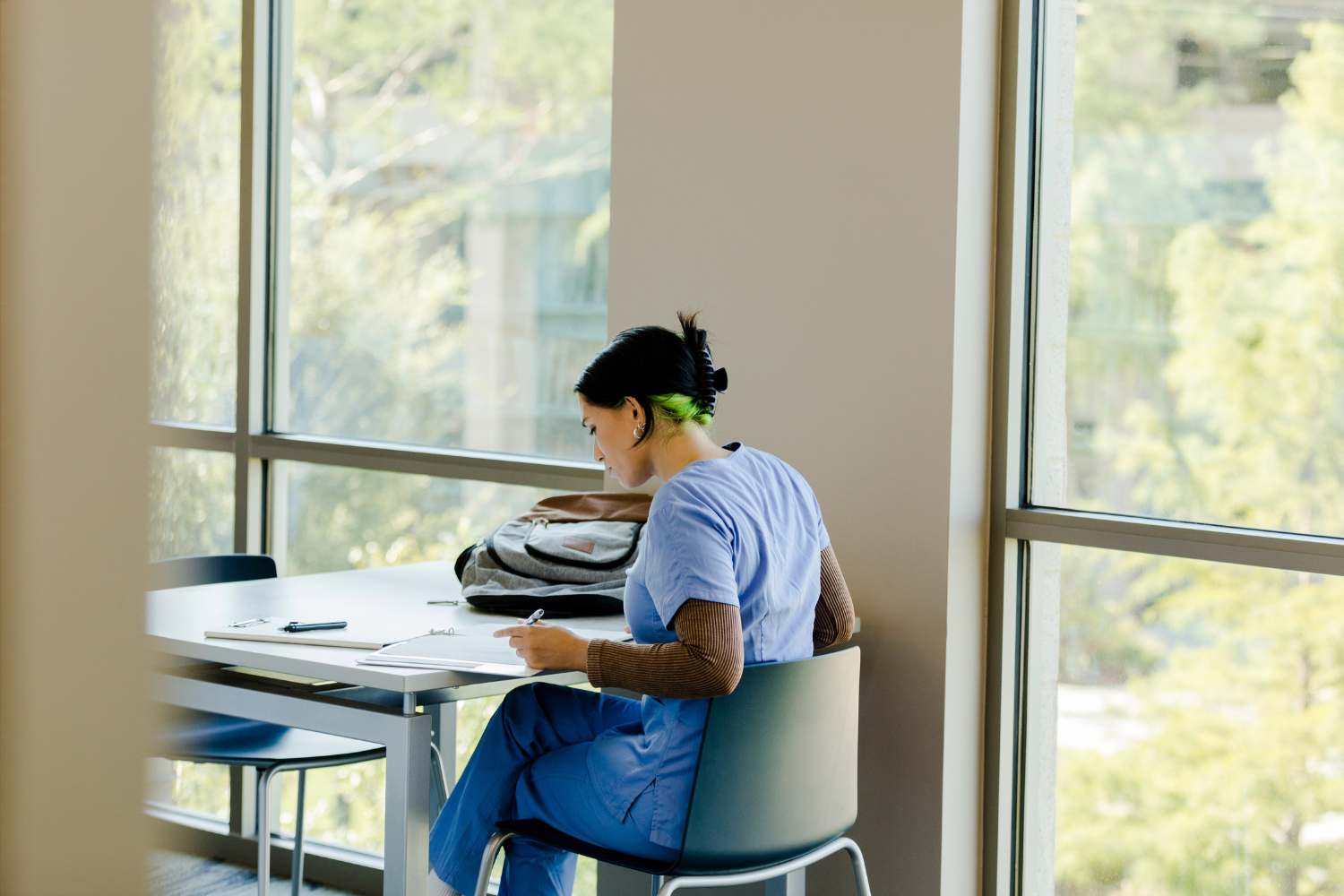 Resident studying- 1500 x 1000 Woman in scrubs studying